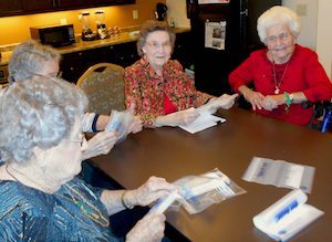 Residents of Brightwater Senior Living label bags for the Food Bank of the Golden Crescent. Residents of Brightwater Senior Living label bags for the Food Bank of the Golden Crescent.